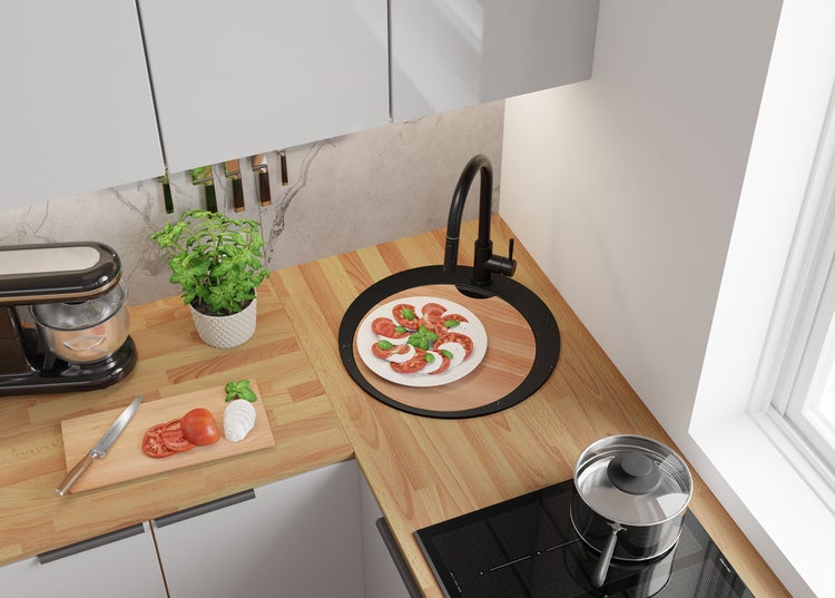 Küchenszene mit Spüle, Kochfeld, Küchenmaschine und Zutaten für Caprese