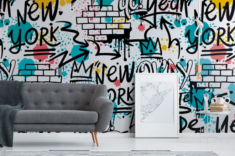 Wohnraum mit Sofa und Wandtapete mit Graffiti-Motiv