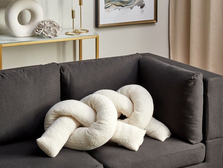 Dekoratives Knotenkissen auf einem Sofa