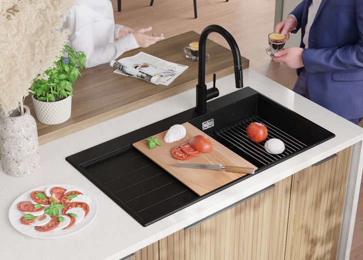 Küchenszene mit Spüle, Armatur, Schneidebrett und Lebensmitteln auf einer Küchentheke