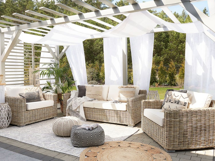 Terrasse mit Pergola, Sitzgruppe aus Rattan, Teppichen und Dekorationen