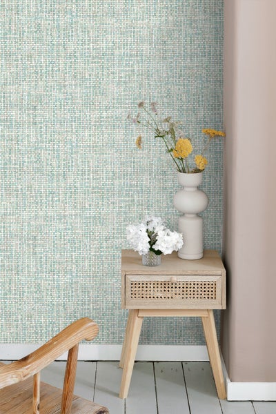 Szene mit gemusterter Tapete und einem kleinen Beistelltisch mit Dekoration