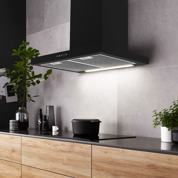 Moderne schwarze Wand-Dunstabzugshaube mit LED-Beleuchtung und Fettfiltern über einem Kochfeld in einer hellen Küche mit Holzschränken.