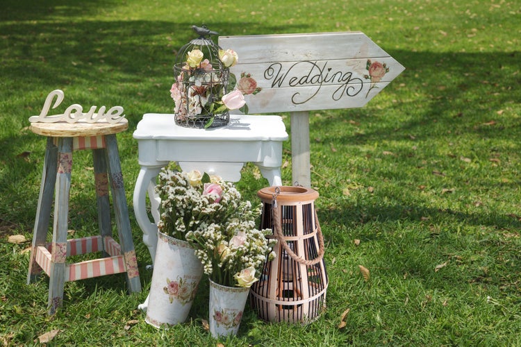 Dekorative Hochzeitsszene mit Wegweiser, Blumen und Laterne im Freien