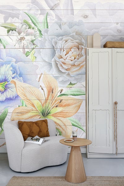 Dekorative Wand mit Blumenmuster neben einem Sessel und einem Beistelltisch.