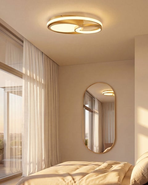 Moderne runde LED Deckenleuchte in einem hellen Schlafzimmer mit ovalem Wandspiegel und bodentiefen Fenstern mit Vorhängen.