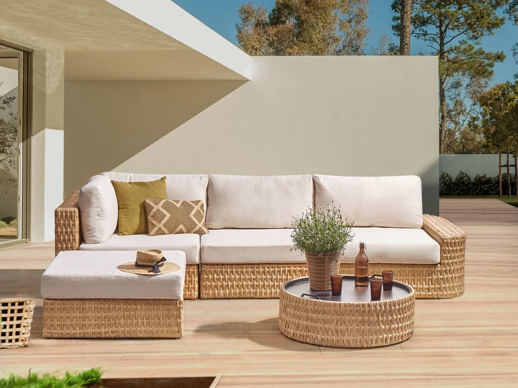 Wohnlandschaft mit Rattan-Optik, Tisch und Hocker auf einer Terrasse