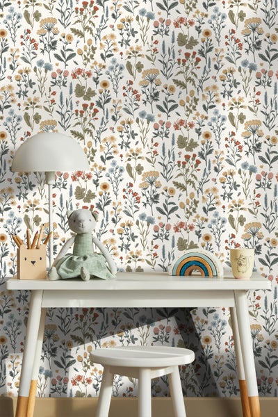Kinderzimmer mit Blumentapete, Schreibtisch, Lampe und Spielzeug