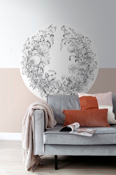 Dekoratives florales Wandtattoo über einem grauen Sofa mit Kissen und einer Zeitschrift