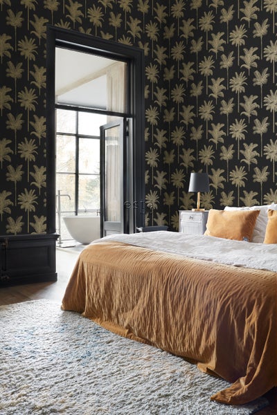 Schlafzimmer mit dunkler Tapete mit Palmenmuster, Bett und Badewanne im Hintergrund