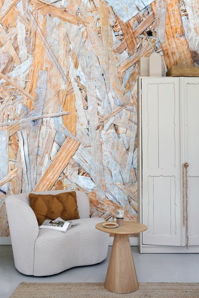 Wohnraum mit OSB-Wandtapete, Sessel, Holztisch und weißem Schrank für ein gemütliches Ambiente