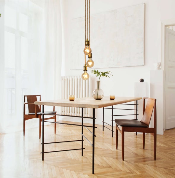 Helles Wohnzimmer mit Sofa, Couchtisch, Hocker, Lampe und dekorativen Elementen