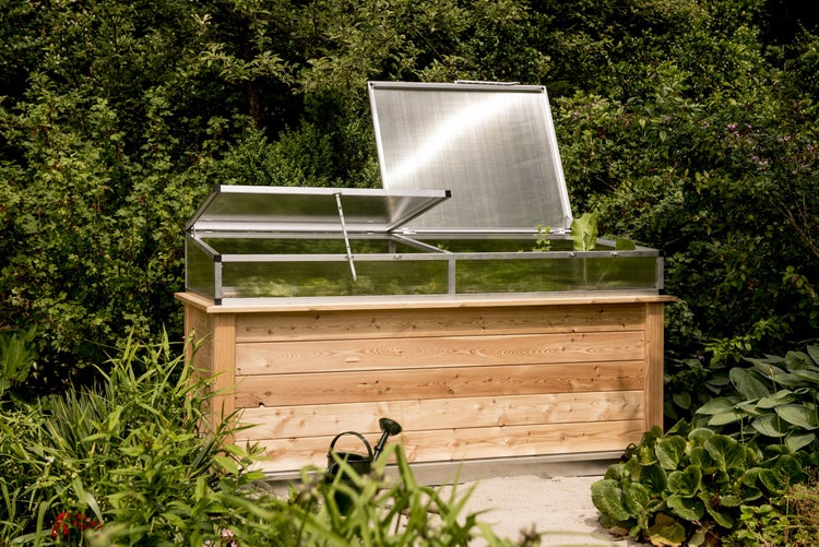 Hochbeet aus Holz mit einem Frühbeetaufsatz aus Aluminium und Polycarbonat in einem hellen Garten.