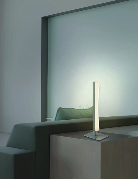 Moderne Stehlampe mit quadratischem Fuß und vertikalem Lichtelement in einem Wohnzimmer.