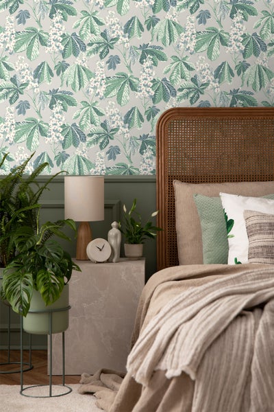 Helles Schlafzimmer mit dekorativer Tapete, Bett und Kaminofen.