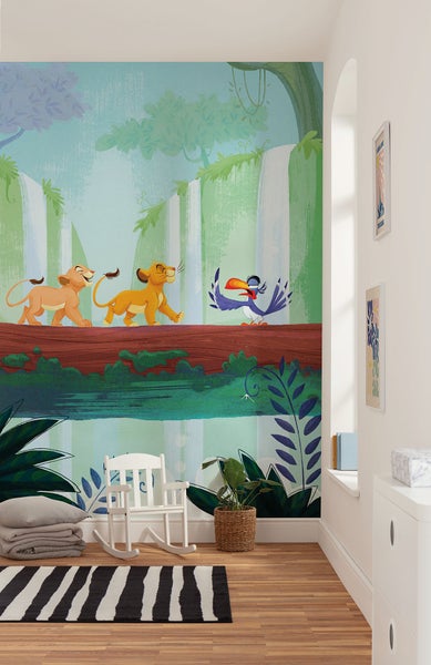 Kinderzimmer mit einer Fototapete mit Dschungelmotiven, inklusive einer Szene aus Der König der Löwen, einem Schaukelstuhl, einem Teppich und Pflanzen.