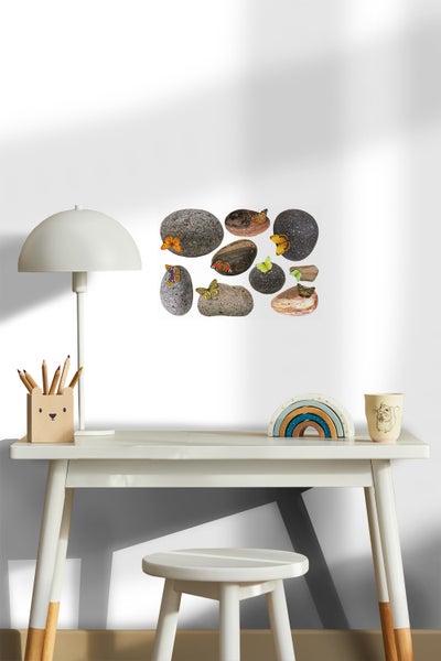 Dekoratives Kinderzimmer mit Schreibtisch, Lampe, Stuhl und Wandbild Steine mit Schmetterlingen