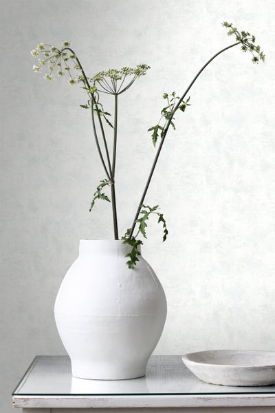 Dekorative Blumenvase mit Pflanzen auf einem Tisch