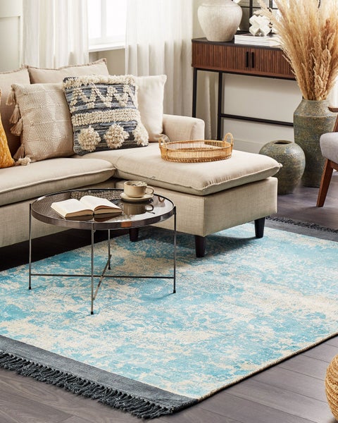 Wohnzimmer mit Sofa, Couchtisch und abstraktem Teppich