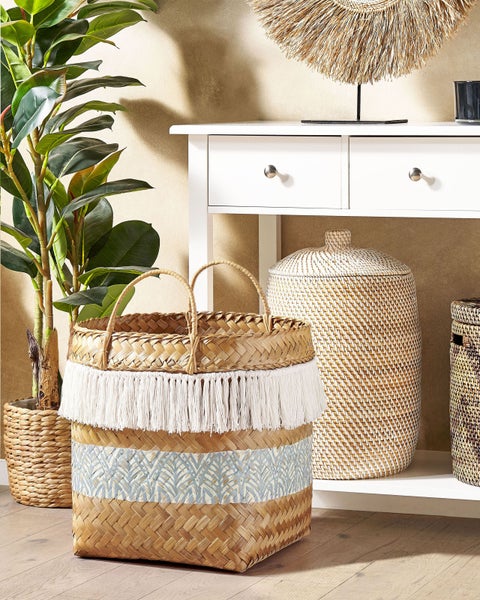Dekorative geflochtene Körbe und eine weiße Konsole in einem Wohnzimmer.