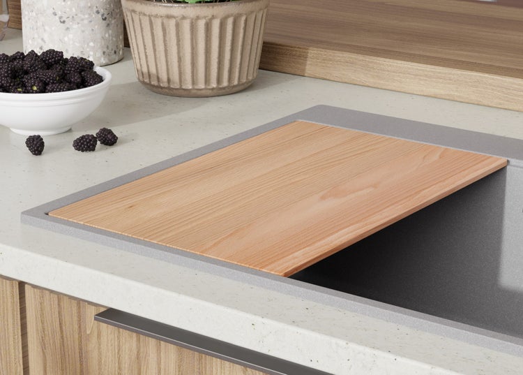 Spüle mit Schneidebrett aus Holz, sowie Schale mit Brombeeren auf einer Arbeitsfläche