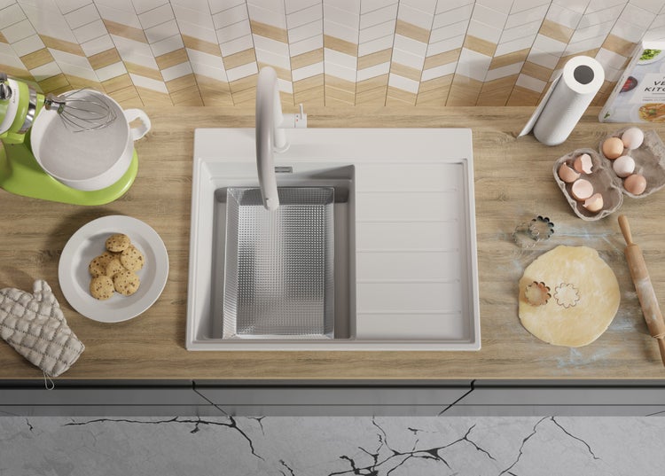 Küchenszene mit Spüle, Armatur, Mixer, Teig und Backzutaten auf einer Küchentheke.