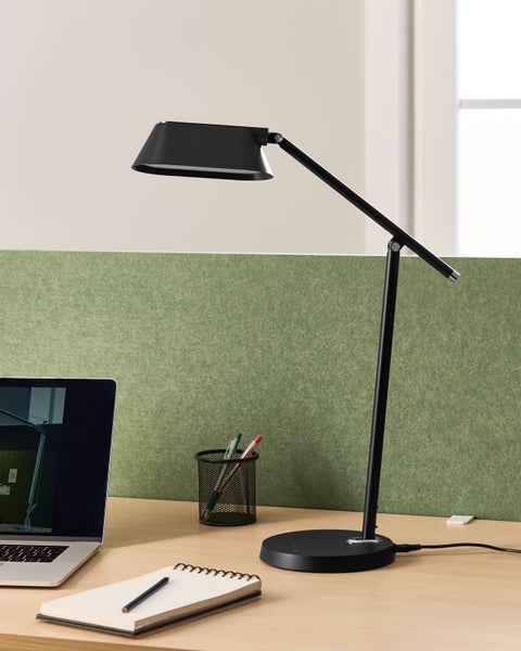 Schreibtischszene mit schwarzer Schreibtischlampe, Laptop, Notizblock und Stifthalter