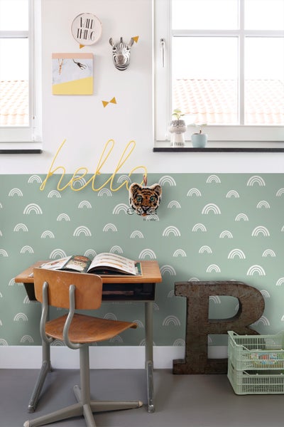 Ein Kinderzimmer mit Schreibtisch, Stuhl und Wanddekorationen.