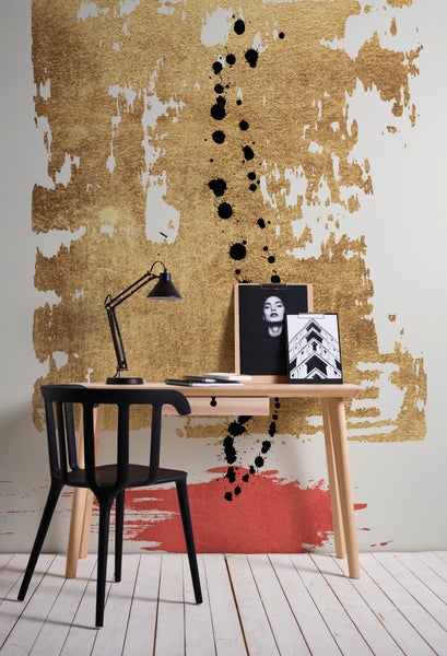 Fototapete mit abstraktem Muster aus Gold, Rot und Schwarz in einem modernen Arbeitszimmer mit Holzschreibtisch, schwarzem Stuhl und Lampe.