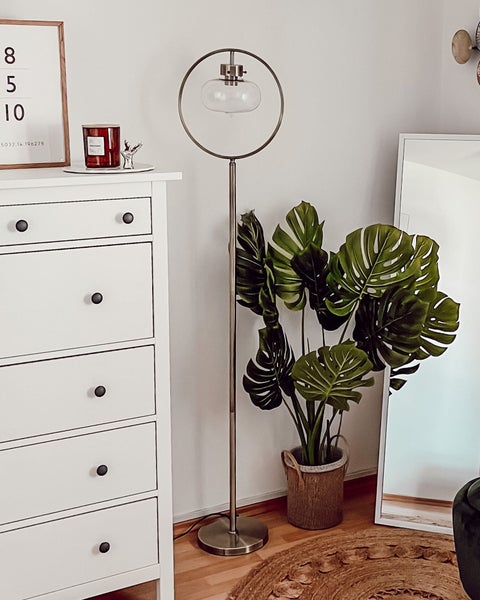 Szene mit Kommode, Stehlampe und Zimmerpflanze