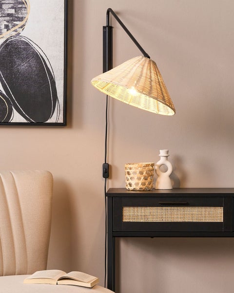 Innenaufnahme eines Zimmers mit einem Sessel, einem Nachttisch und einer Wandlampe