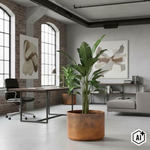 Zimmerpflanze im zylindrischen Pflanzkübel in Rost-Optik in einem hellen Büro im Loft-Stil mit Ziegelwand und Schreibtisch.