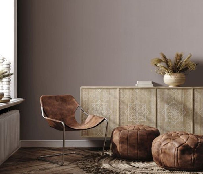 Dekoratives Zimmer mit gemusterter Tapete, Fenster und Blumenarrangements.