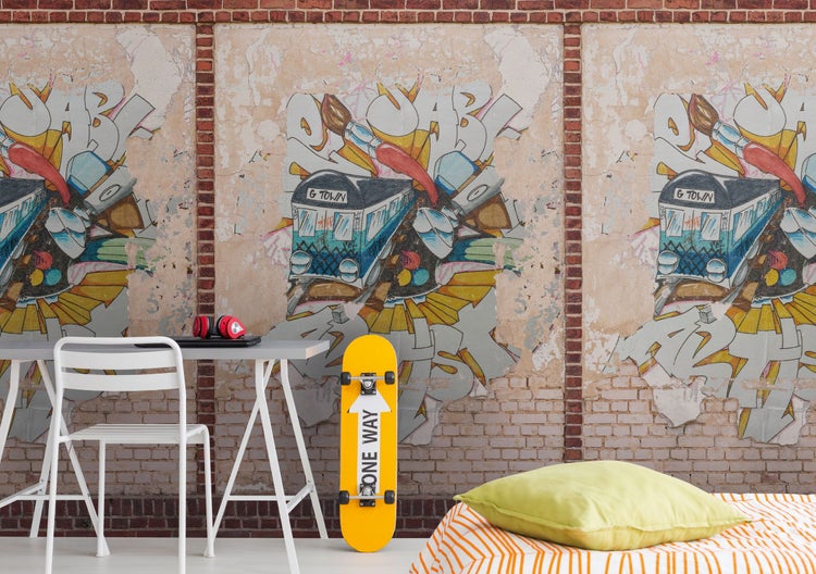 Dekoratives Zimmer mit Schreibtisch, Stuhl, Skateboard und Wandtapete mit Graffiti-Motiven
