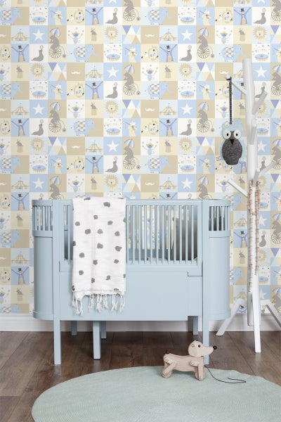 Kinderzimmer mit blauem Gitterbett, Zirkustapete und Holzspielzeug