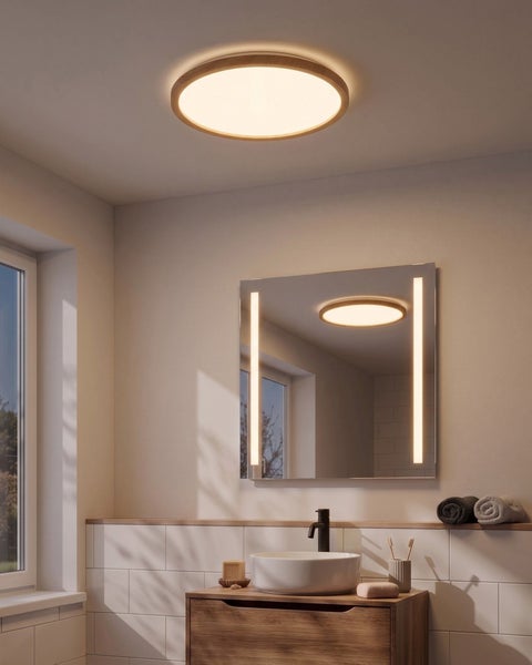 Modernes Badezimmer mit rundem Deckenlicht und quadratischem Spiegel mit vertikaler Beleuchtung über einem Waschtisch mit Waschschüssel.