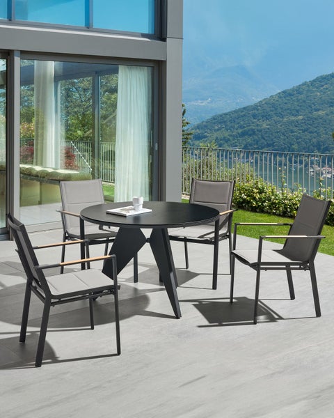 Gartensitzgruppe mit rundem Tisch und vier Stühlen auf einer Terrasse mit Bergblick