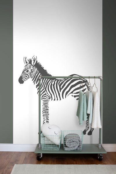 Wandgestaltung mit Zebra-Wandtattoo und Rollgarderobe mit Textilien und Aufbewahrungskörben.