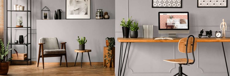 Modernes Heimbüro und Wohnbereich mit grauen Wänden, Holzmöbeln, Schreibtisch, Sessel und Zimmerpflanzen.