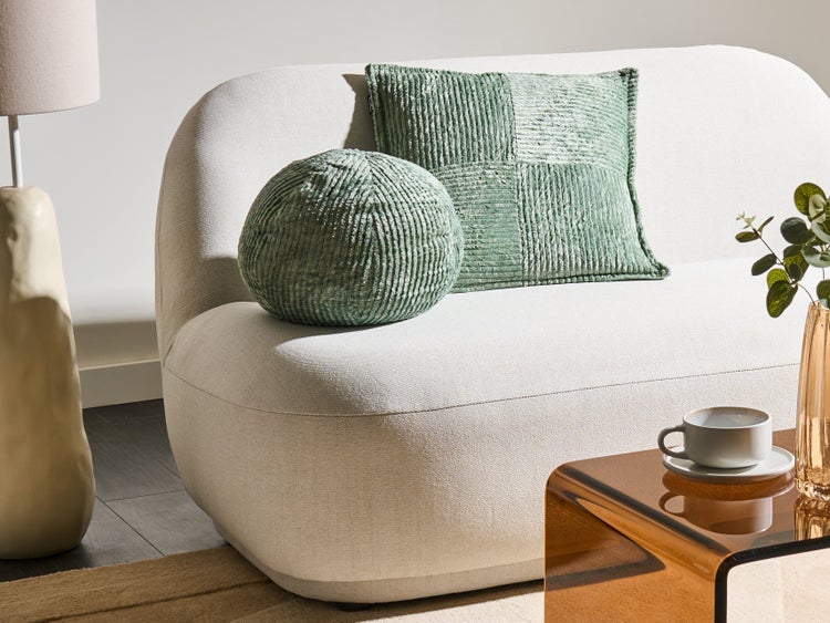 Szene mit Sofa, Kissen, Tischlampe und Beistelltisch