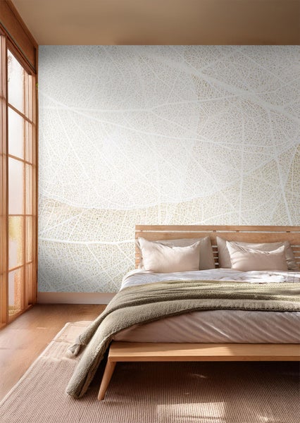 Schlafzimmer mit Bett und Tapete mit Blattmotiv