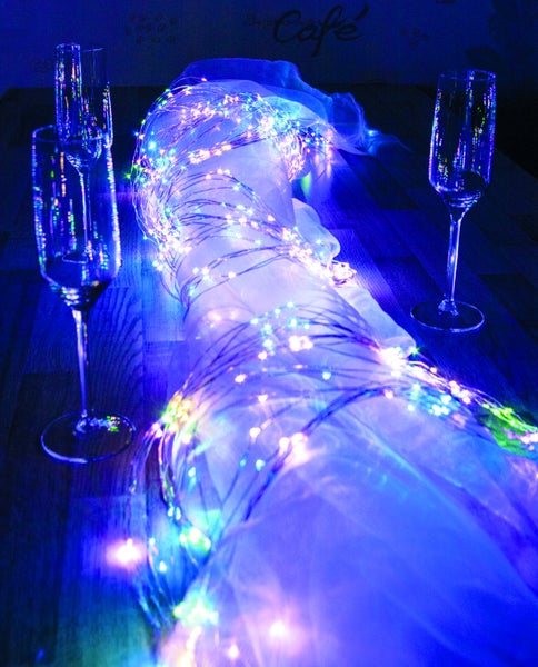 Dekoration mit Lichterkette und Sektgläsern auf einem Tisch