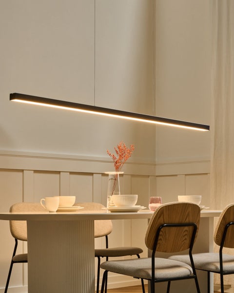 Lineare schwarze LED-Pendelleuchte über einem gedeckten Esstisch in einem modernen Esszimmer mit Stühlen und Wandpaneelen.