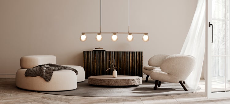 Wohnzimmer mit Sofa, Sesseln, Tisch, Kommode und Pendelleuchte