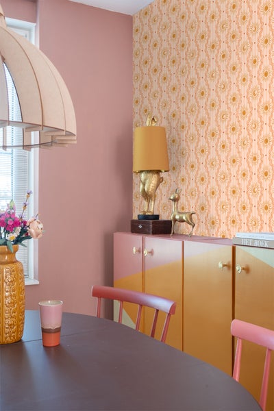Esszimmer mit Esstisch, Stühlen, Schrank und dekorativer Tapete