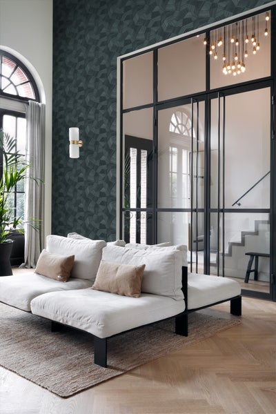 Wohnzimmer mit weißem Sofa, gemusterter Tapete und Glastür