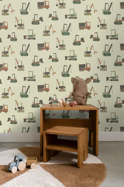 Kindertapete mit Baustellenfahrzeugen in einem Kinderzimmer mit Holzmöbeln und Spielzeug.