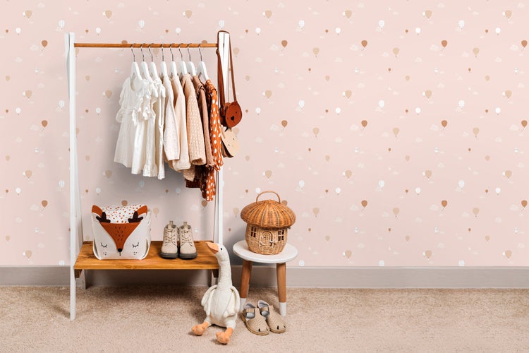 Kinderzimmer mit Kleiderständer, Kleidung, Spielzeug und Accessoires.