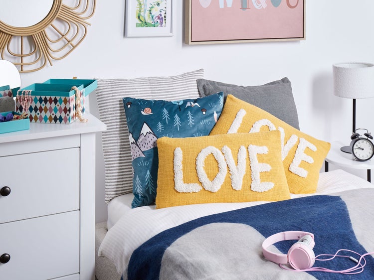 Dekoratives Schlafzimmer mit Bett, Kissen, Kommode und Accessoires für Kinder