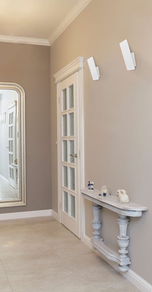 Flur mit Spiegel, Tür mit Glaseinsätzen, Konsole und Wandleuchten